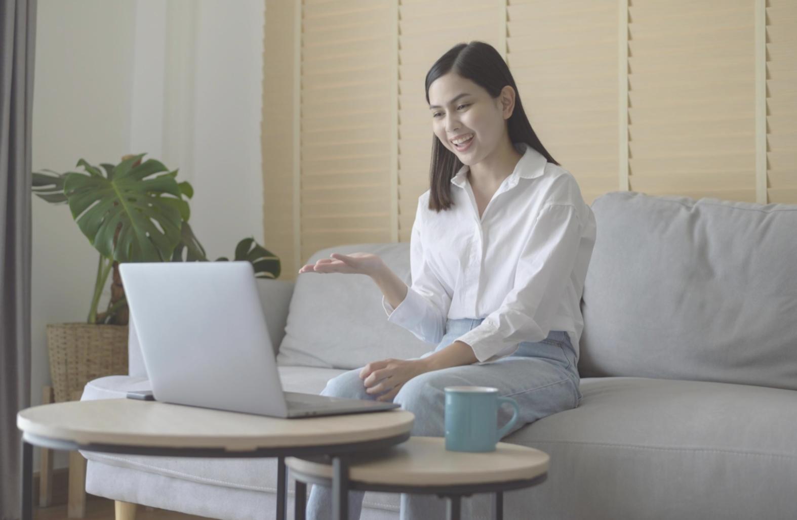 Person reviewing financial documents with laptop and notebook, demonstrating methodical approach to money management